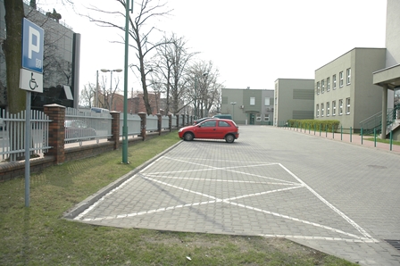 ZUS - miejsca parkingowe, na pierwszym palnie koperty, w tle stoi jeden samochód